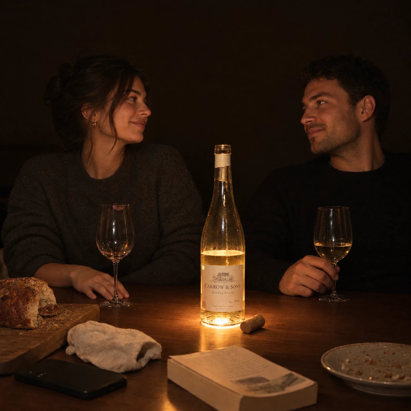 Two people at a table lit by one glowing bottle