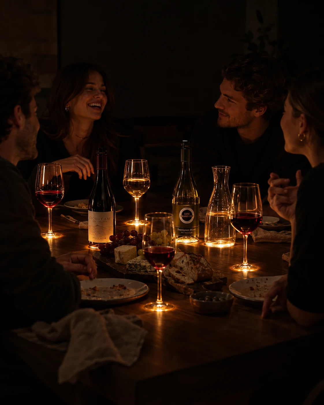 Friends at a table, glasses lit from below